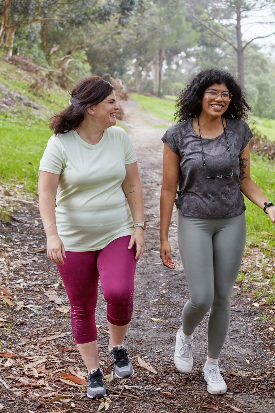 Two friends walking together on a wooded path